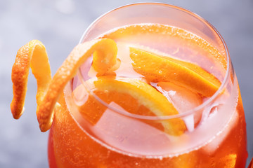 Classic italian aperitif aperol spritz cocktail in glass with slice of orange on dark background,...