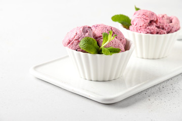 Homemade berry ice cream in bowls on white background. Close up. Space for text.