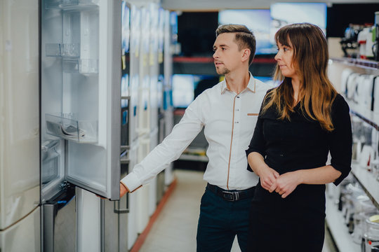 Satisfied customers choosing fridges in appliances store 