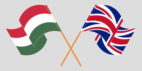 Crossed and waving flags of Hungary and the UK
