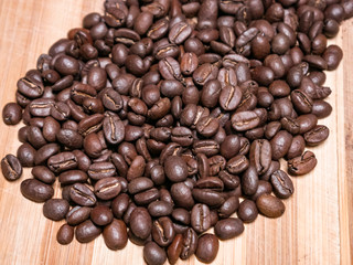 Large coffee beans on wooden board