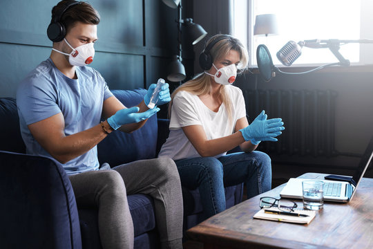 Radio hosts disinfecting hands before going live - Powered by Adobe