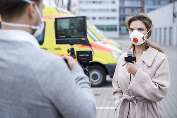 TV news reporters are making reportage about a virus epidemic in the city