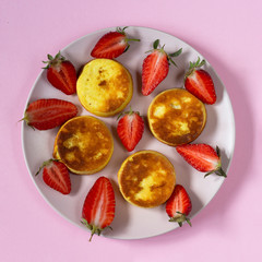 Homemade Cottage Cheese Pancakes with Strawberry on pink background. Top view.