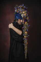 a man with blue flowers on a dark background