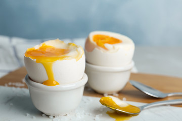 Soft boiled chicken eggs on white table, closeup