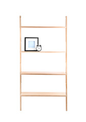 Wooden shelving unit with photo frame and alarm clock isolated on white
