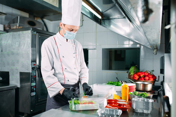 Food delivery in the restaurant. The chef prepares food in the restaurant and packs it in disposable dishes.