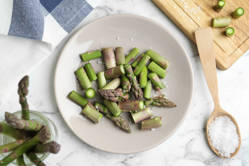 Fresh raw asparagus on white marble table, flat lay