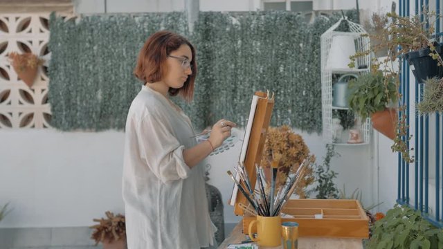 muchacha joven pintora con blusa pintando retrato en &oacute;leo