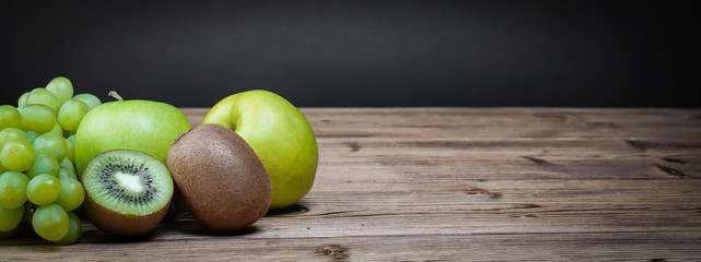 Banner vegetarian healthy food. Source of protein for vegetarians. Healthy eating: grapes, apple, kiwi on wooden background.