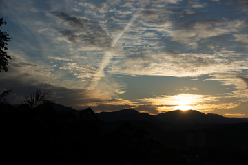 Nascer do Sol com Montanhas e céu azul com nuvens