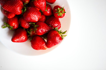 Close up. Fresh ripe delicious strawberries in a white bowl isolated on white background. Beautiful Italian red strawberry. European eco food without pesticides and additives in Milan, Lombardy, Italy