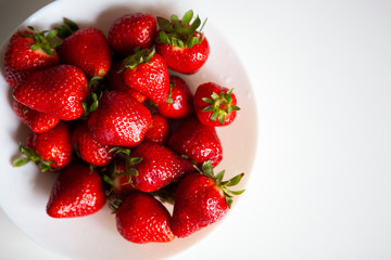 Close up. Fresh ripe delicious strawberries in a white bowl isolated on white background. Beautiful Italian red strawberry. European eco food without pesticides and additives in Milan, Lombardy, Italy