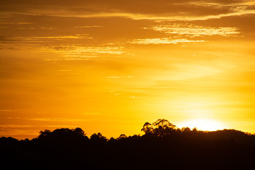 nascer do sol com silhueta de árvores e montanhas