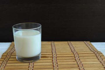 A glass of natural milk. Milk in a glass on a wooden background