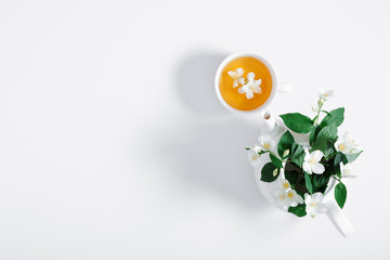 Jasmine flowers and teapot on white background. Herbal tea of jasmine flower. Jasmine tea concept....