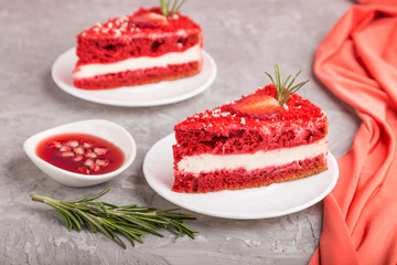 Homemade red velvet cake with milk cream and strawberry on a gray concrete background. side view, selective focus.