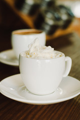 Hot coffee in a white ceramic cup on a wooden table. Morning homemade coffee. Relaxing time concept. Copy space. Selective focus.