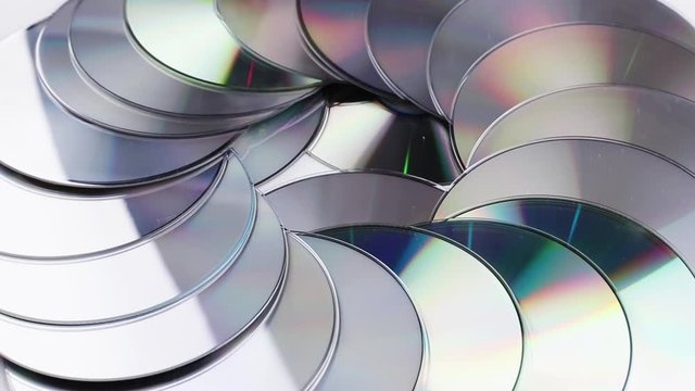 abstract background with compact discs rotating. obsolete electronic data devices with colourful rainbow reflection close-up