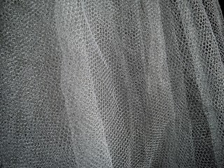 White wrinkled mesh fabric. A washable thing made of synthetic material. Mosquito net folded into...