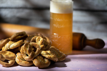 pretzel or homemade crackers with beer and rolling pin in window light