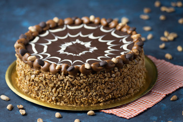 chocolate cake with dulce de leche and peanut with white chocolate decoration with blue background