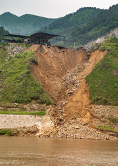 Huangqikou, Chongqing, China - May 8, 2010: Yangtze River. Collapsed shoreliine with brown dirt...