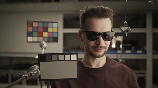 RAW video, ungraded. Man testing professional film camera. ColorChecker Gray Scale, Classic Card and spidercube. It helps to ensure eccurate color balance. ARRI Alexa Mini, Lens 32 mm