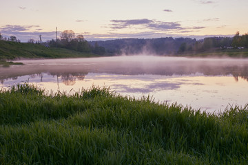 Obraz na płótnie Canvas On a misty spring evening landscape. Fog over the river and forest.