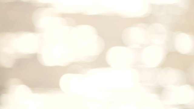 defocused shot of small ripple wave in sea, shiny sparkling sunlight reflection in water with bokeh of sun glares , blurry ocean on sunny day, abstract and blackground concept