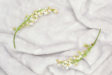 Obraz na płótnie Canvas Gray fur background with bird cherry flowers. Copy space in the middle