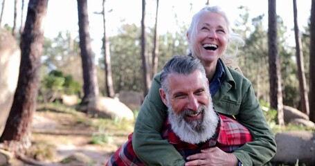 Close up senior woman piggyback senior man at forest - Powered by Adobe