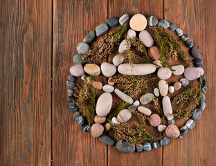Obraz na płótnie Canvas Pentagram made of stones with heather branches on a wooden background. Top view.