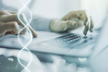 Creative concept with DNA symbol illustration and hands typing on laptop on background. Genome...