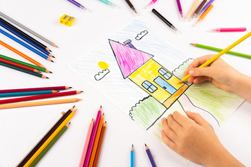 Naklejka premium A child draws a house. Homemade creativity. Bright picture on white paper.