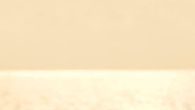 defocused shot of small ripple wave in sea, shiny sparkling sunlight reflection in water with bokeh of sun glares , blurry ocean on sunny day, abstract and blackground concept