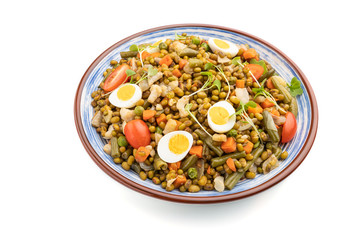 Mung bean porridge with quail eggs, tomatoes and microgreen sprouts isolated on a white background. Side view.