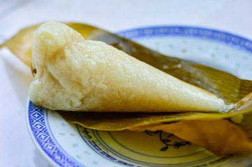 Chinese homemade zongzi on white plate. Zongzi is the traditional Chinese rice dumplings for Dragon Boat Festival (Duanwu Festival).