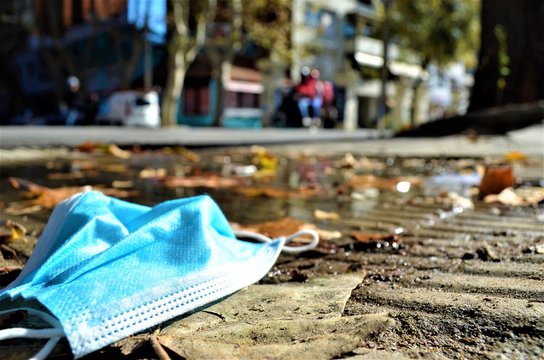 charco con tapaboca desechable y hojas de arboles