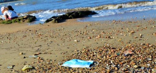 disposable face mask on the beach
