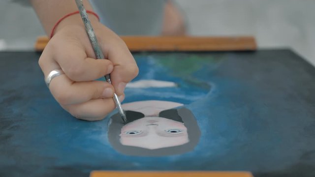vista de cerca y desde arriba de mano pintando cuadro al &oacute;leo