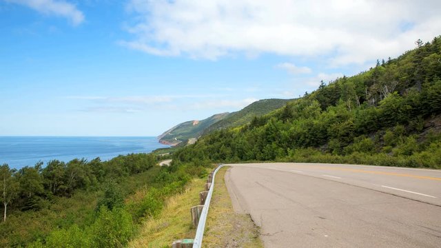 A timelapse of the Cabot Trail overlooking the Atlantic Ocean and the winding highway shot on the middle of a summer afternoon