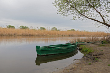Obraz premium Lonely old wooden boat by the river in a quiet place