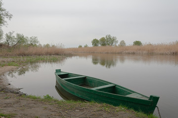 Naklejka na ściany i meble Lonely old wooden boat by the river in a quiet place