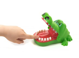 Child shoved finger into mouth of toy crocodile