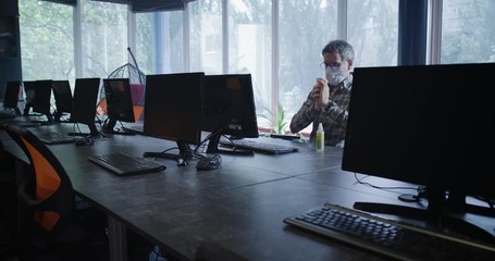 Man disinfecting hands in workplace