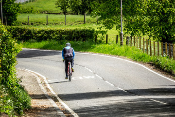 An older man cycling during the lockdown caused by coronavirus, outdoor exercises, Scotland, UK - 350398518