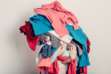 Mommy little helper. Cute Caucasian girl sorting clothes. Adorable funny child arranging organazing clothing. Kid holding messy stack pile of clothes, things. Home chores housework. - 350402301