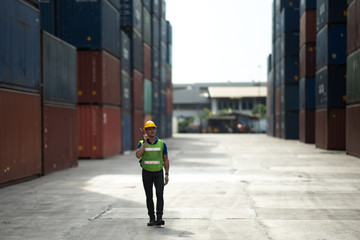 engineer, foreman walking in shipping container terminal yard, business working in term of international transportations, import and export the product